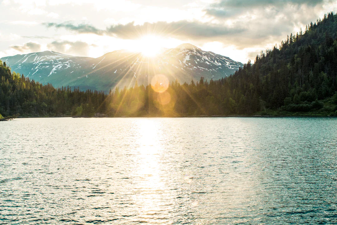 Sun rising over an Alaska mountain and lake