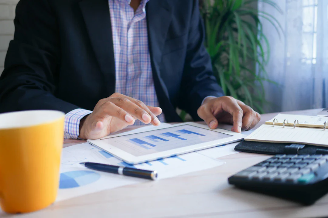 Person reviewing financial charts at a desk with a calculator